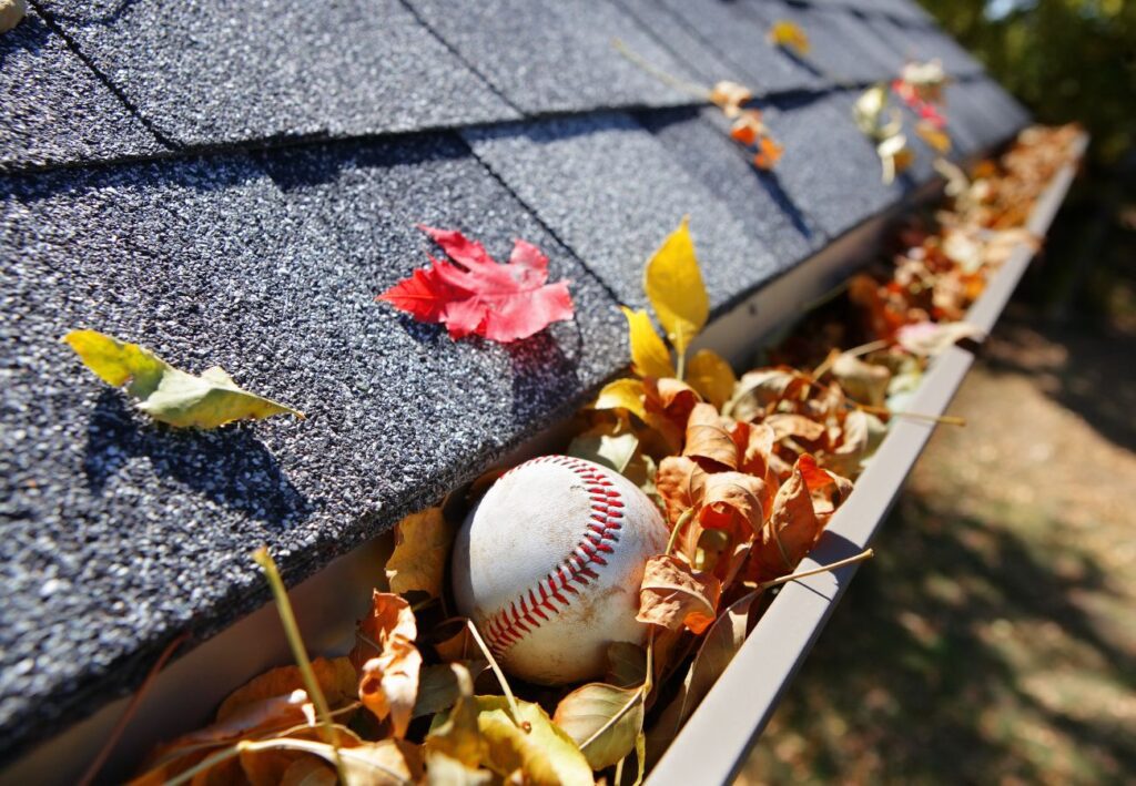 a baseball is sitting on the roof of a gutter