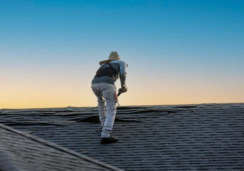 a man on a roof with a hat on