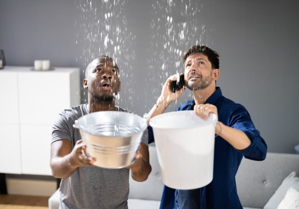 two men holding buckets and talking on the phone