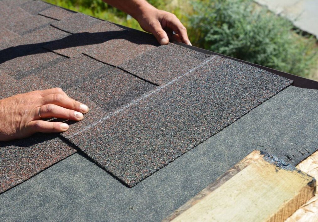 a person is installing a roof shingle