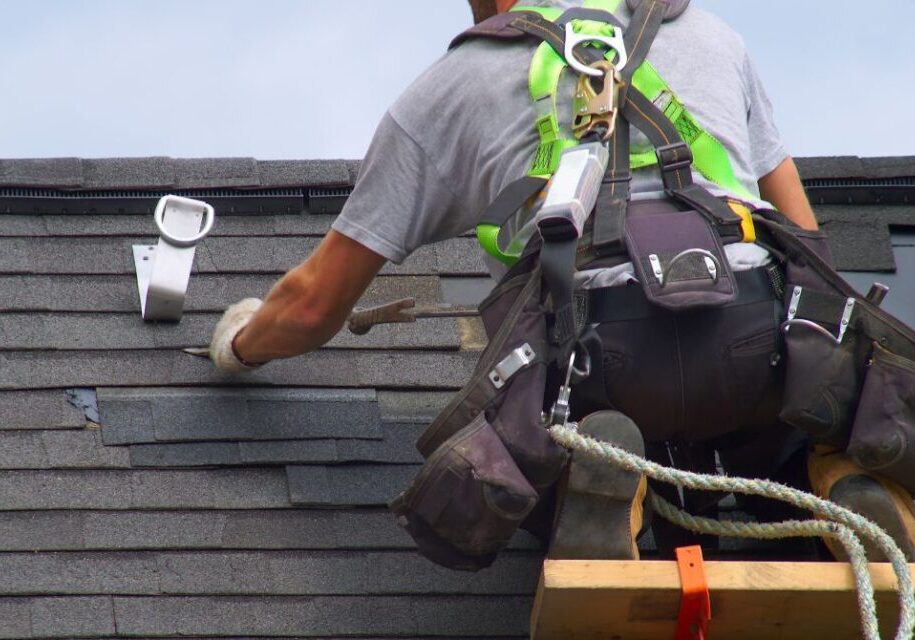 a man is working on a roof with a ladder